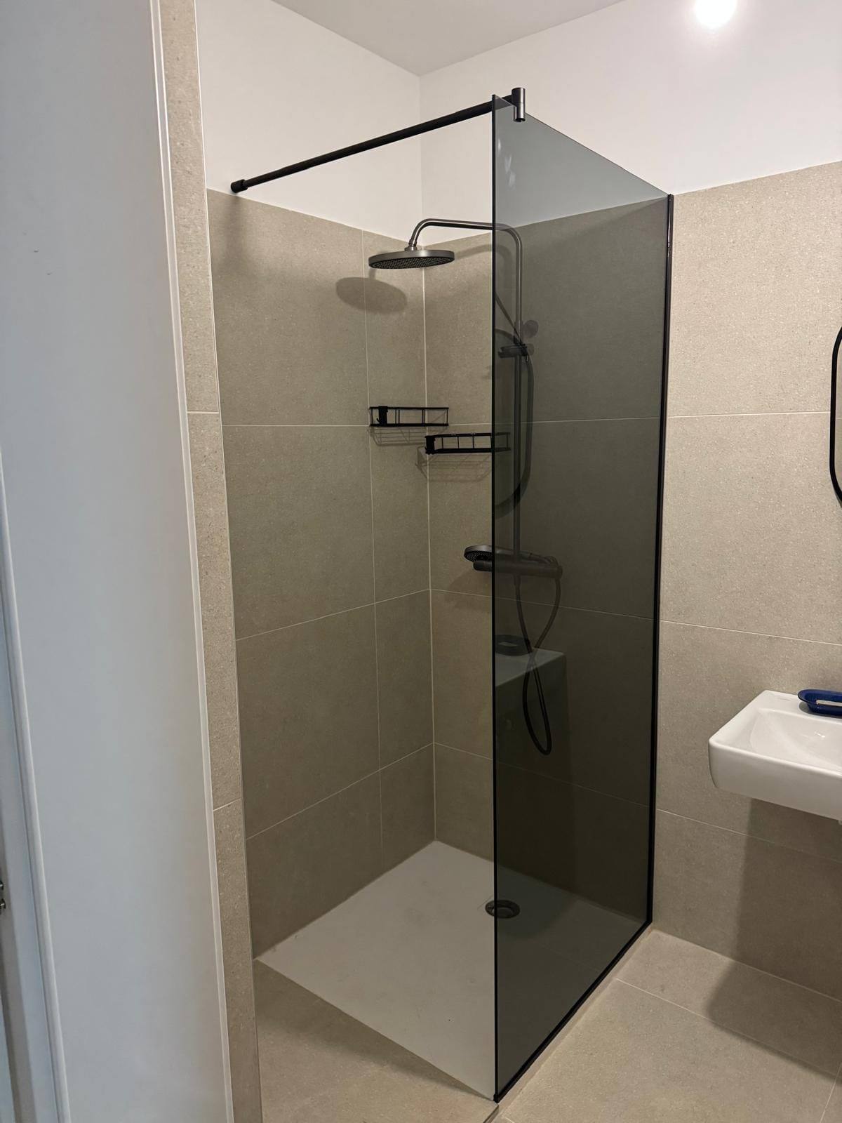 Walk-in Duschkabine mit Rauchglas-Trennwand und schwarzen Profilen, Maßanfertigung MK Glas in einer Altbauwohnung in 1180 Wien Währing