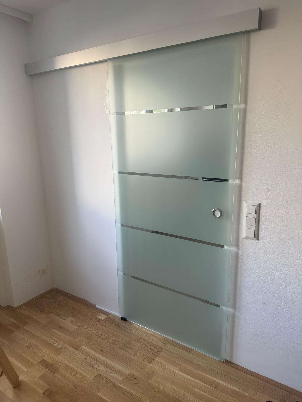 Glas-Schiebetür mit horizontalen Streifenätzungen in Wien Josefstadt 1080
